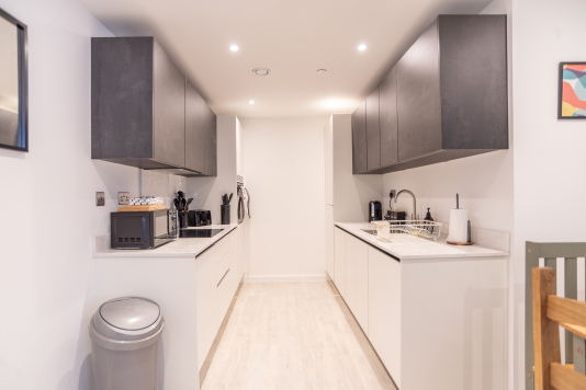Modern fully equipped kitchen with oven, microwave, kettle and all essentials for cooking.