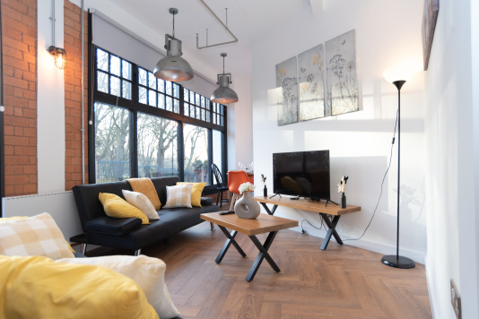 A cosy, welcoming living room with two sofa beds sleeping one guest each, all bedding provided, a full 4K Smart TV and dining space for up to 8 people, with beautiful large windows creating a bright, open entertainment space for you and your colleagues, friends or family