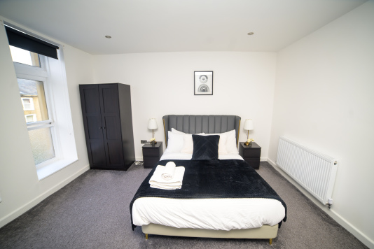 Sleep easy in this spacious double bedroom with soft linens and a relaxing ambience.