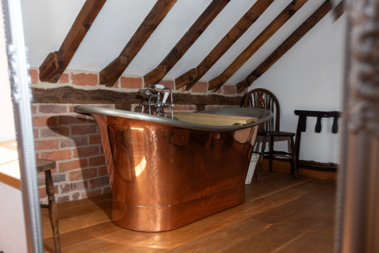 Freestanding copper bathtub in the bedroom for the ultimate luxury, spa-style experience