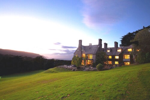 Evening view of bossington hall from the garden, lights on int he house, clear sky