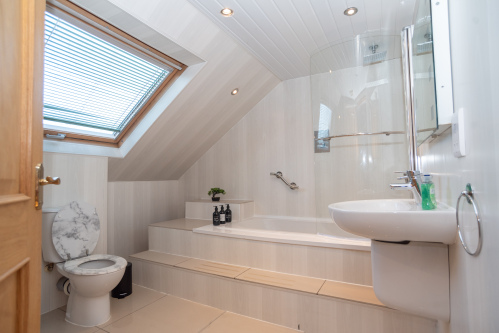 Sunken bath, forming part of one of four bathrooms in this generously sized home