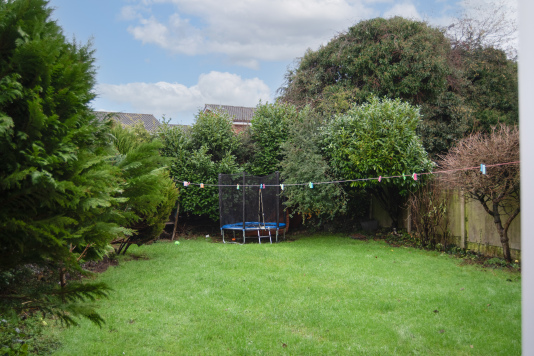 A large, private south-facing garden with patio, outdoor seating, washing line and trampoline — perfect for relaxing summer evenings with family or colleagues in a peaceful central Telford setting.