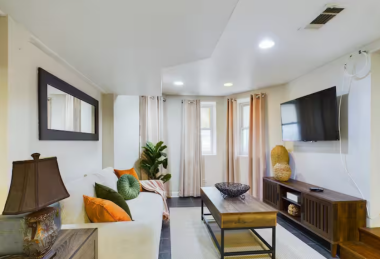 Unwind in this modern living room featuring a 55” smart TV, chic wooden coffee table, and soft lighting. With cozy seating and large windows, it’s a perfect spot to relax or enjoy quality time with loved ones.