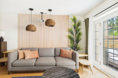 The living room’s soft seating and layered textures create a cozy nook for movie nights or lazy mornings.