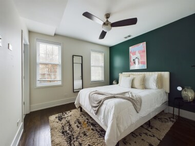 Rest easy in this stylish queen bedroom, featuring a comfortable bed, ample closet space, and modern decor. The calming green accent wall adds a touch of elegance, making it the perfect retreat for a peaceful night’s sleep.
