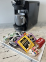 Tassimo coffee machine with complimentary tex, coffee, milk, and biscuits.