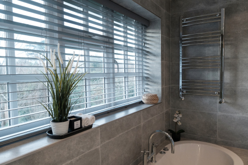 The fully tiled bathroom with a large, luxurious bath, separate shower enclosure, wash basin, heated towel rail and W.C.