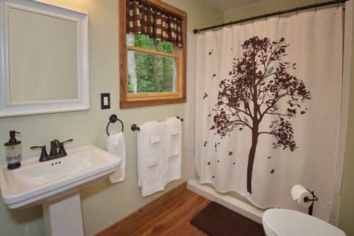 The spacious bathroom includes a large step-in shower and ample plush linens.