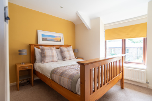 The yellow room catches the morning sun - a warm, cheerful double for two with courtyard views, hotel style bedding and linens