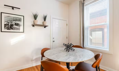 The round marble-top dining table and chic leather seating offer the perfect spot to enjoy a coffee with a book or newspaper, setting a relaxed and sophisticated tone for your day.