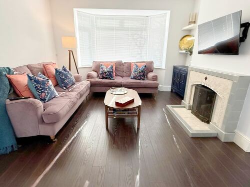 Unwind in this elegant living room, featuring two cozy two-seater sofas and a sleek TV. With warm lighting and stylish décor, it’s the perfect spot to relax after exploring.