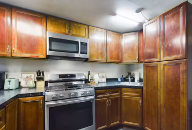 Cook in style with this well-equipped kitchen featuring stainless steel appliances, a gas stove, and elegant wooden cabinetry. Perfect for creating culinary masterpieces or enjoying casual meals in a warm and inviting atmosphere.