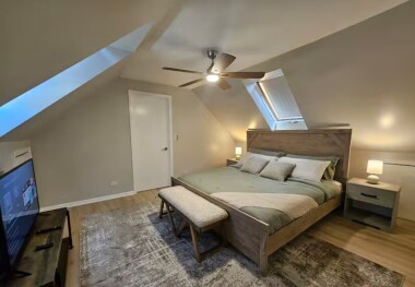 Relax in this spacious master bedroom featuring a luxurious king-size bed and a 40-inch TV for your entertainment. The room’s vaulted ceilings, skylights, and cozy decor create a serene and inviting atmosphere for a restful night’s sleep.