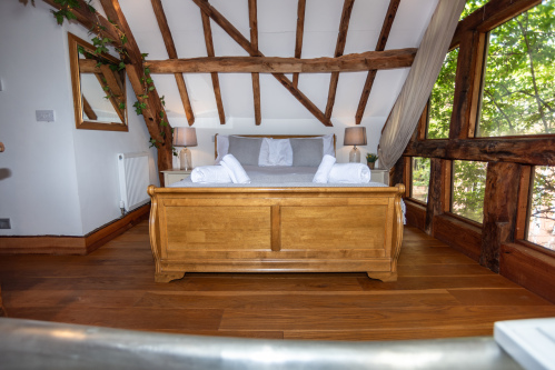 Elegant, luxury bedroom with calming treehouse charm and thoughtful design throughout
