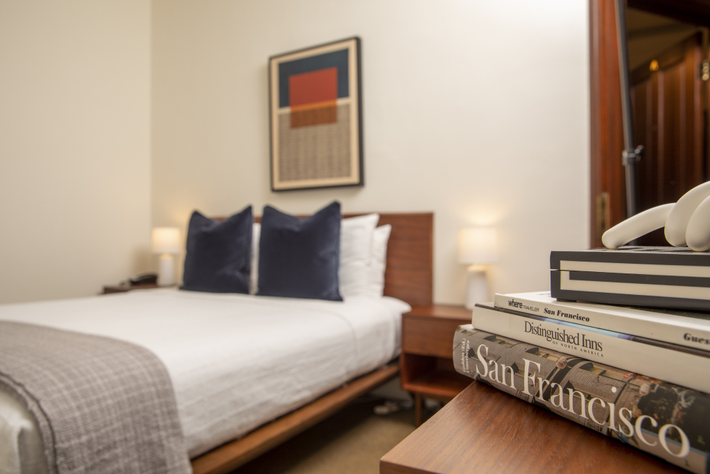 A neatly made bed with pillows and a throw blanket in a room with a modern aesthetic.