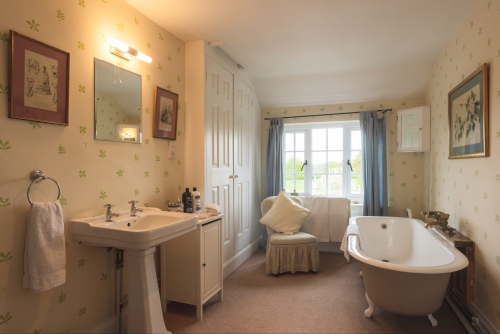 Spacious ensuite bathroom with a large Victorian roll-top bath