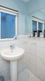 Clean, fresh and bright modern fitted bathroom, with walk in shower large mirror and a snuggly warm towel radiator.