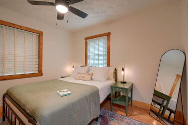 Primary bedroom with celing fan, night stands, lamps with charging stations