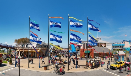 A lively outdoor scene with flags, people, and buildings.