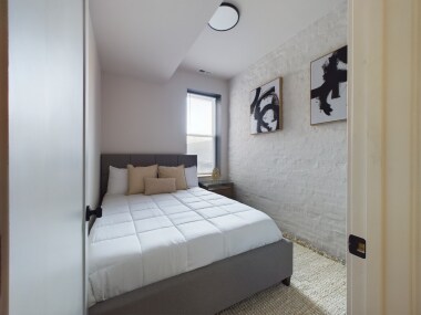 Step into this serene bedroom where natural light filters through, highlighting soft earthy tones and a tranquil ambiance. The cozy bed, surrounded by simple yet elegant decor, offers the perfect retreat for unwinding and embracing a sense of calm.
