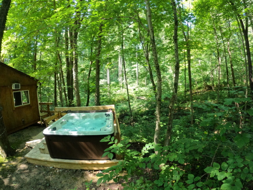 Hot Tub in the Woods with Deck and Entrance to Cabin