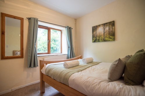 Comfortable double bedroom dressed in calming countryside tones for a restful night's sleep.