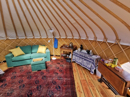 Ash Yurt living space with large double sofa bed and kitchenette 