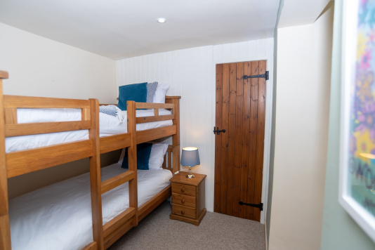 The bunk room is built for adventure — solid oak beds that sleep two, with built in wardrobes and area for games