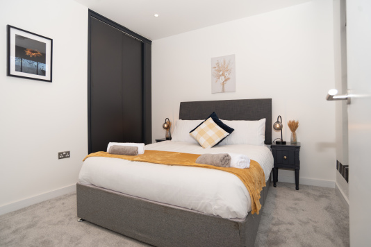 A comfortable double bedroom with built-in wardrobe storage and crisp hotel-quality linens, professionally cleaned between stays and ideal for both short and longer-term visits.