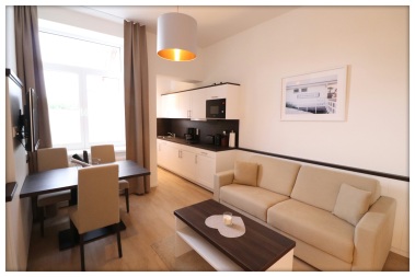 Wohnbereich mit hochwertiger Schlafcouch, Esstisch, TV und Küchenzeile