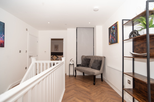 A large, spacious upstairs hallway with seating, parquet flooring and beautiful décor, enhanced by modern LED, sensory and disco-style lighting — the perfect stylish start to your Birmingham city centre stay.