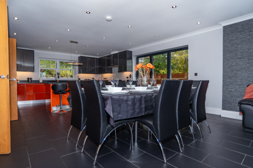 Open-plan kitchen and dining area with a spacious table and extra seating, thoughtfully arranged for easy hosting and comfortable gatherings.