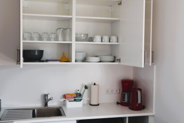 Voll ausgestattete Küche mit Herd, Backofen, Mikrowelle, Kühlschrank, Spülmaschine, Kaffeemaschine, Wasserkocher, Geschirr und Besteck – ideal für die Selbstverpflegung.