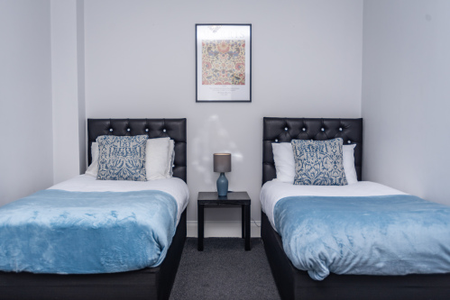 Bedroom with two comfortable single beds, perfect for friends, family, or flexible sleeping arrangements.