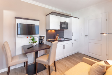 Wohnbereich mit TV, Sofa und Küchenzeile