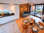 Vue d'ensemble comprenant la salle à manger, la cuisine, le salon avec canapé et la terrasse pour un séjour confortable.
