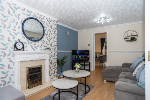 A spacious living room with a full electric reclining sofa, sofa bed, Smart HD TV and a cosy, comfortable setting for relaxing.