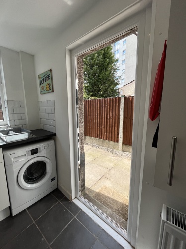 Fully equipped kitchen including washing machine and entrance to back yard