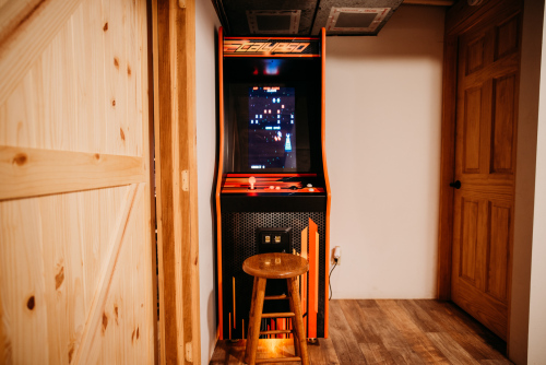 Lower level game room with an arcade machine