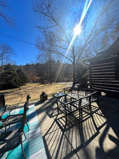 Side patio off the kitchen/mudroom. Table seating, outdoor seating with propane firepit. Gas grill and wood firepit.