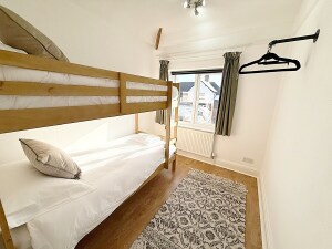 This charming bedroom features a cozy bunk bed, perfect for children. With vibrant décor and a playful atmosphere, it’s the ideal space for little ones to relax and recharge.