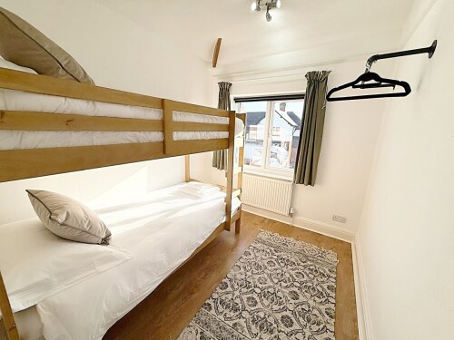 This charming bedroom features a cozy bunk bed, perfect for children. With vibrant décor and a playful atmosphere, it’s the ideal space for little ones to relax and recharge.