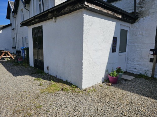 Communal door entrance and flat sign beside door. Key box at top of stairs