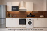 Fully equipped kitchen with large refrigerator & freezer, oven, induction cooktop, kettle, microwave, dishwasher, and washing machine