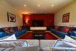 3 Comfortable sofas in living room with large flat-screen TV