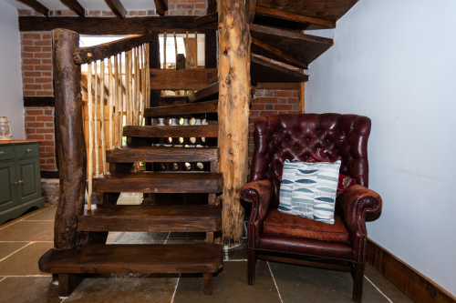 Quirky handcrafted staircase with true treehouse vibes, leading from the living room to the two upstairs bedrooms, dressing area and master bathroom