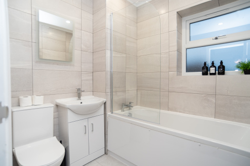Master bathroom complete with complimentary shampoo, conditioner and shower gel in the bath — a clean, well-stocked space for a comfortable, stress-free stay.