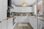 Kitchen with washing machine, microwave, kettle, oven and hob, fredge/freezer