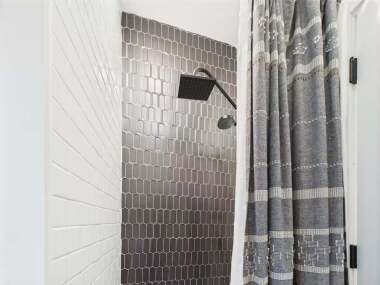 Dark tiles add a touch of drama to this walk-in shower.